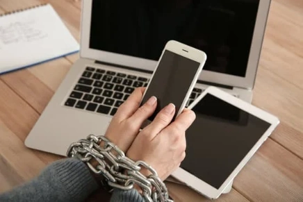 handcuffed arms holding a cell phone