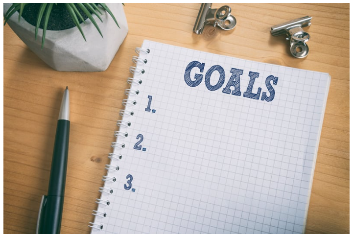 notebook paper with the word goals wriien on it in blue pen